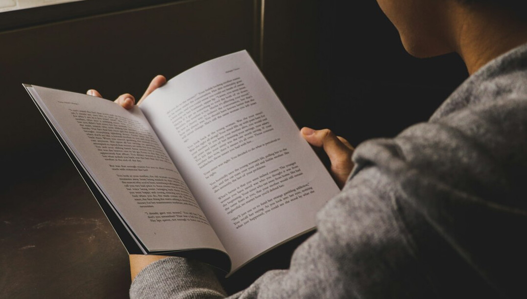 man reading book outdoors